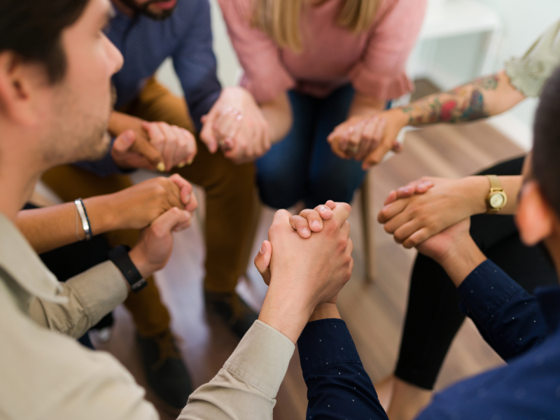 People holding hands in alcoholics anonymous meeting in San Diego